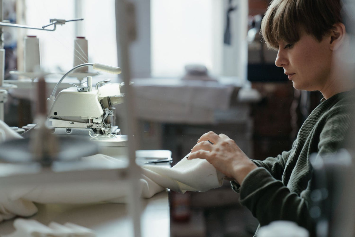 Couturière au travail à sa machine à coudre dans son atelier