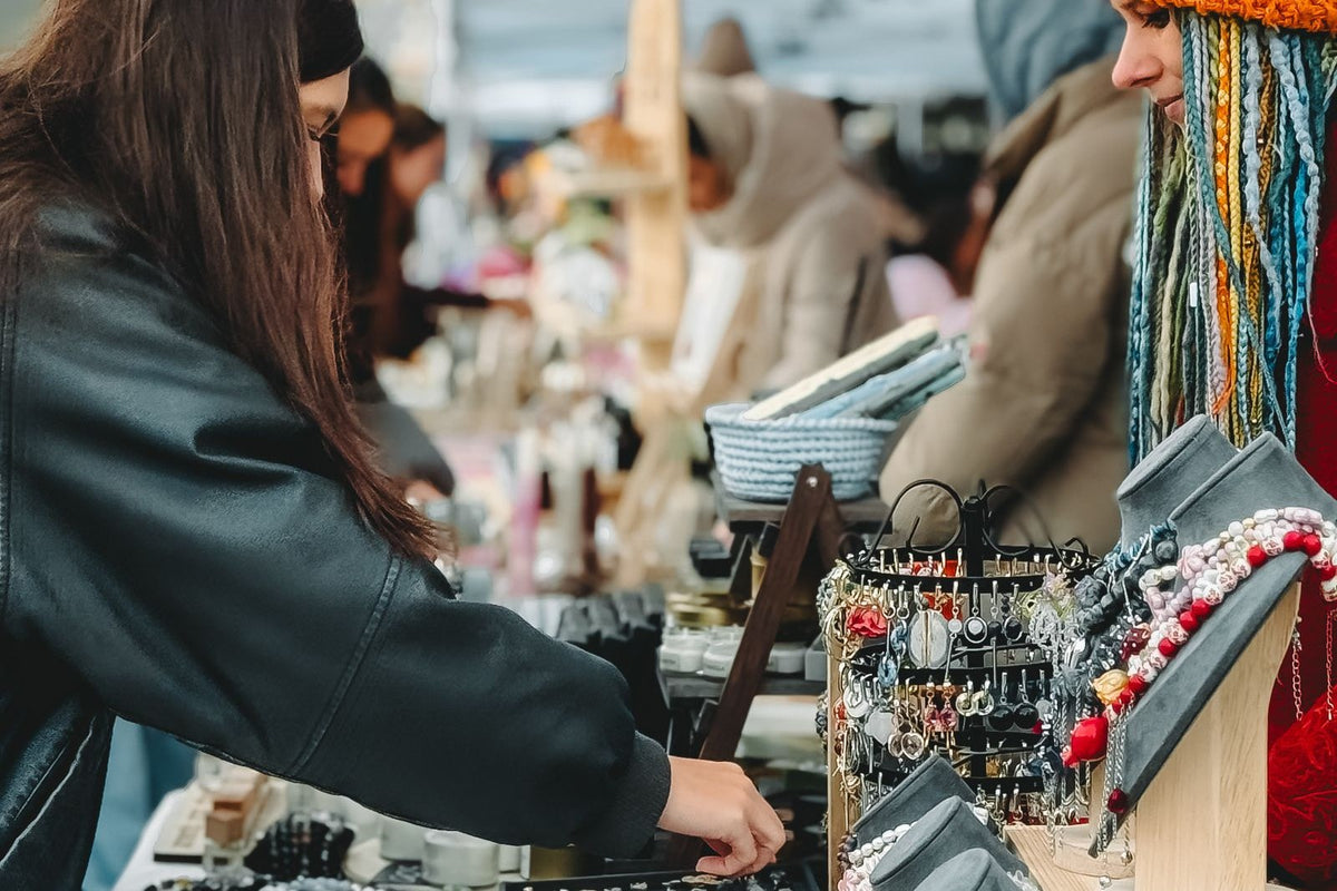 Stand de marché de créateurs, bijoux faits main et articles revendus côte à côte