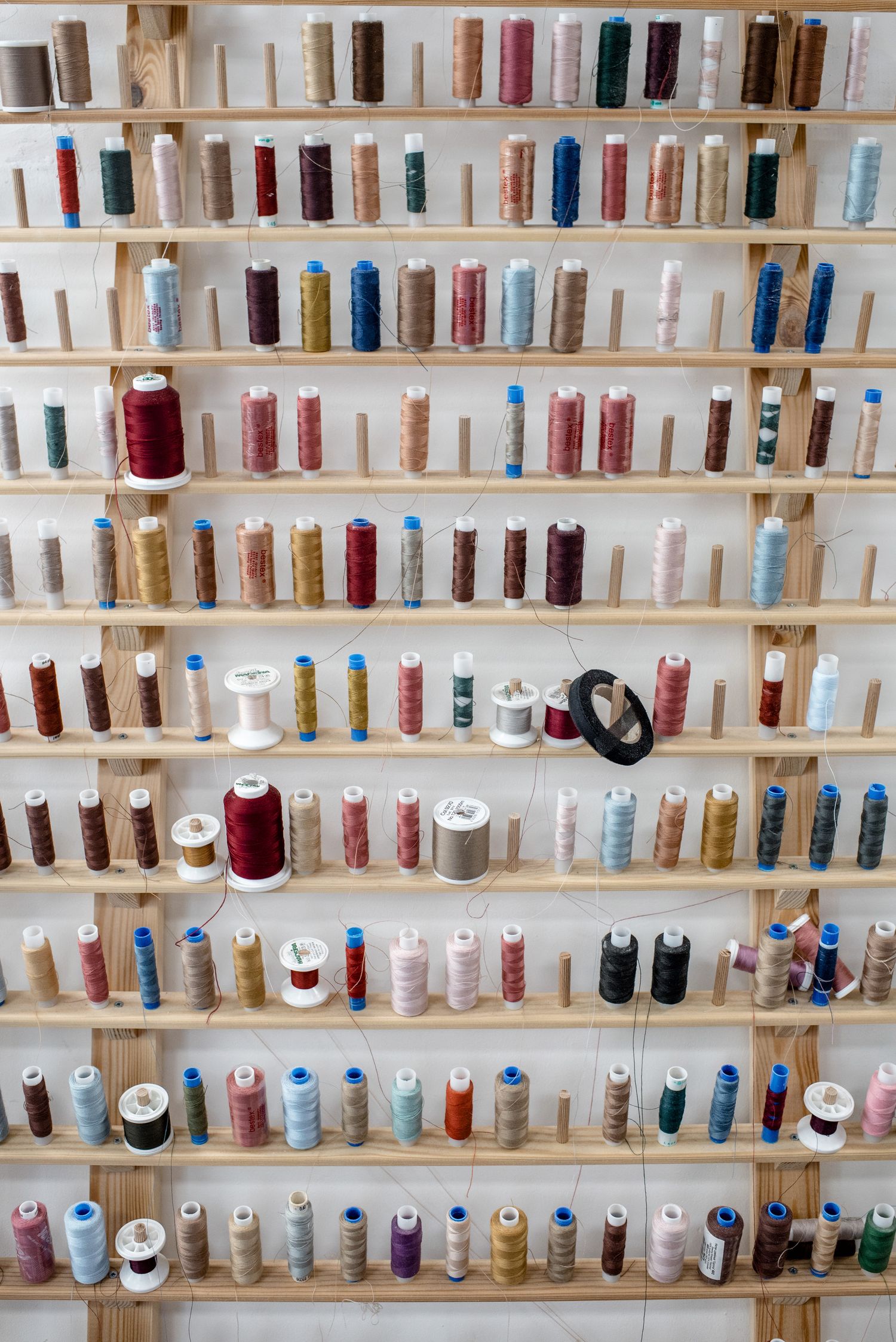 Mur de bobines de fil de toutes les couleurs dans un atelier de couture